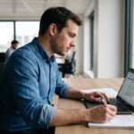 Auditeur financier analysant des documents de salaire et cotisations sociales dans un bureau moderne